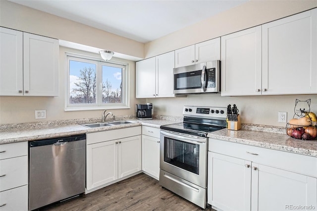 kitchen with sink, dark wood-type flooring, white cabinets, and appliances with stainless steel finishes