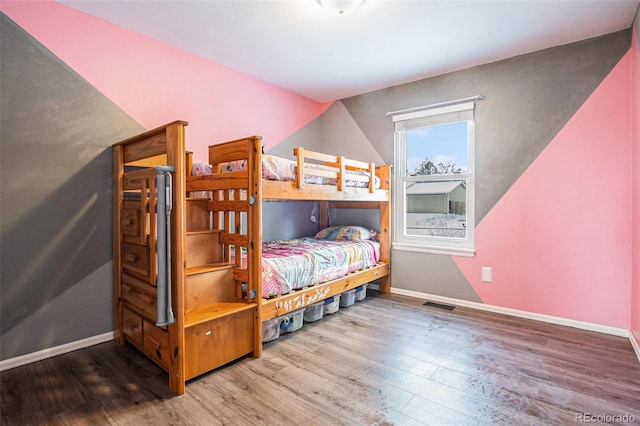 bedroom with lofted ceiling and hardwood / wood-style floors