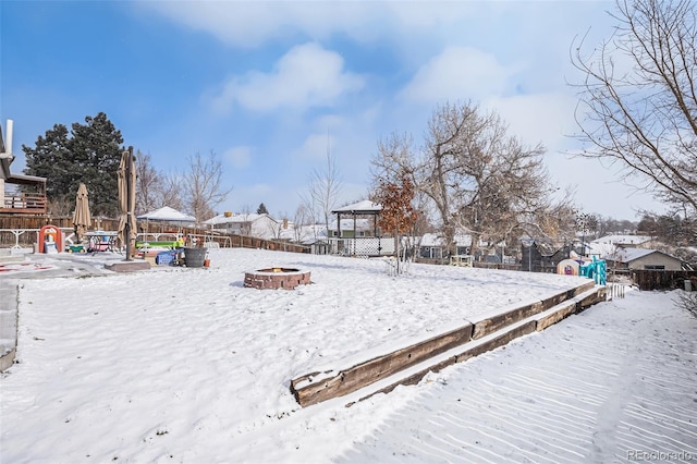 yard covered in snow with an outdoor fire pit