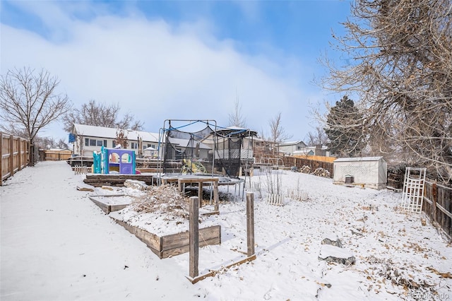 snowy yard featuring a trampoline