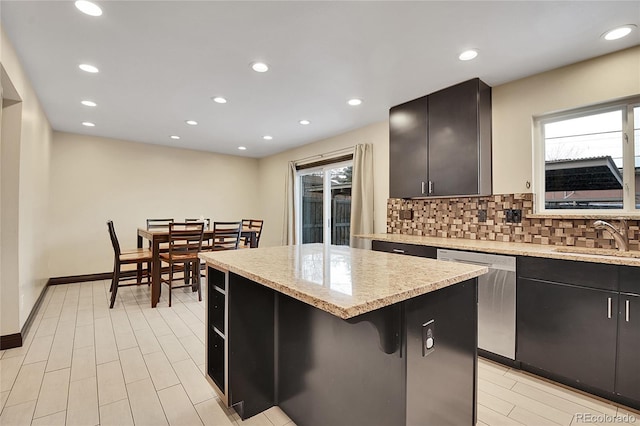 kitchen featuring sink, a breakfast bar, a center island, decorative backsplash, and stainless steel dishwasher