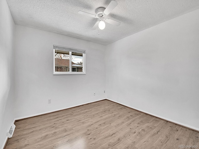 spare room with ceiling fan, light hardwood / wood-style floors, and a textured ceiling