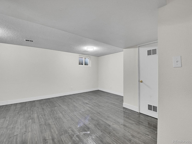 basement with dark hardwood / wood-style flooring and a textured ceiling