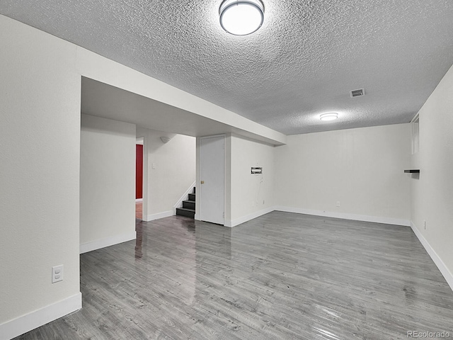 basement with wood-type flooring and a textured ceiling