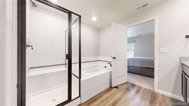 bathroom featuring vanity, separate shower and tub, and hardwood / wood-style flooring