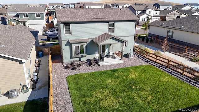 rear view of house featuring central AC, a lawn, and a patio area