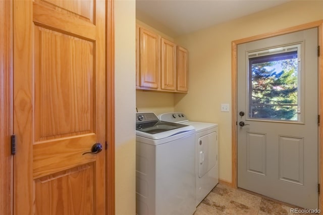 clothes washing area with cabinets and separate washer and dryer