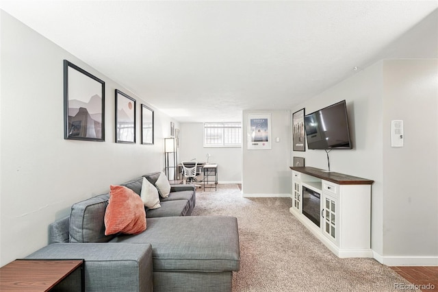 living area featuring baseboards and light carpet