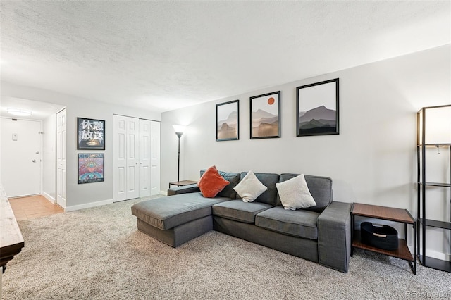 living room with light carpet, baseboards, and a textured ceiling