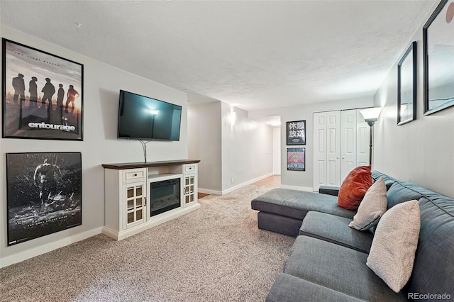 carpeted living area featuring baseboards and a textured ceiling