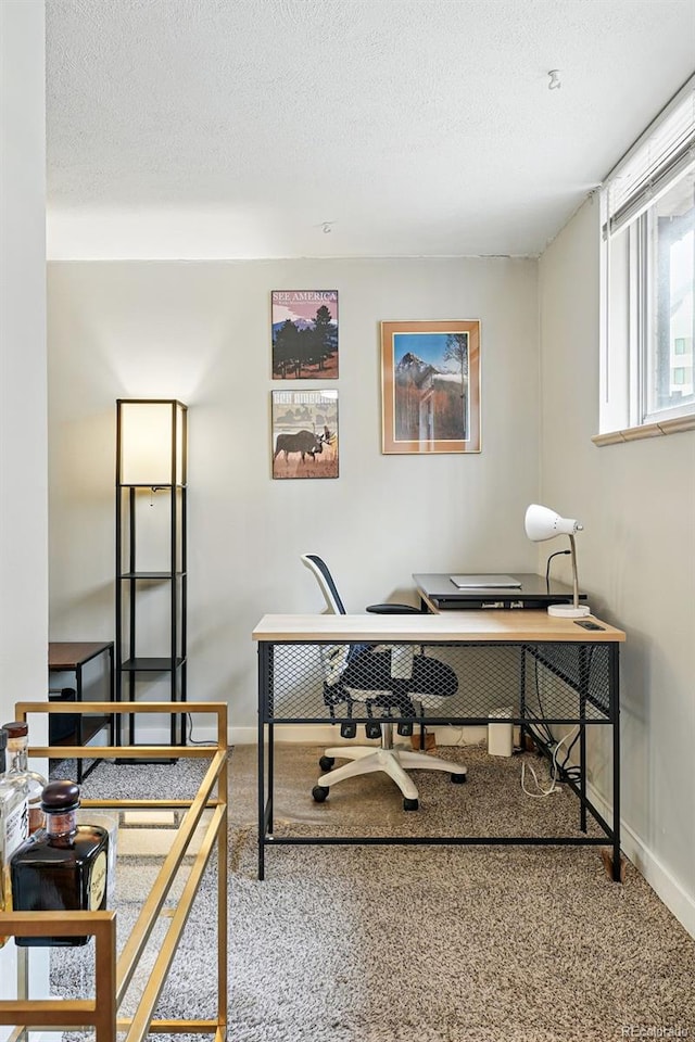home office featuring carpet, baseboards, and a textured ceiling