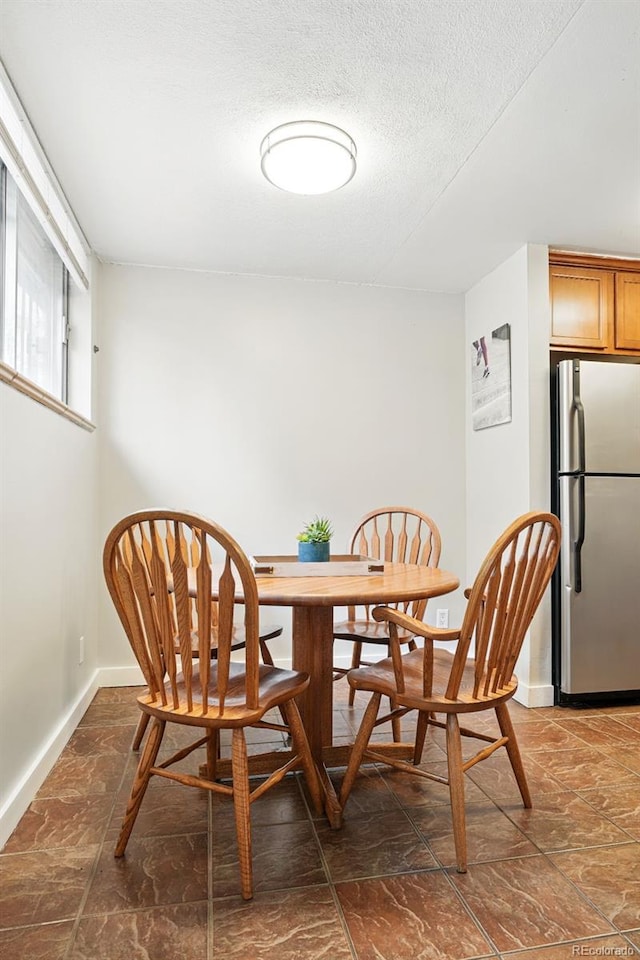dining area featuring baseboards and a textured ceiling
