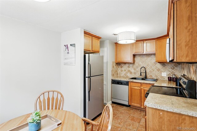 kitchen featuring appliances with stainless steel finishes, a sink, and tasteful backsplash