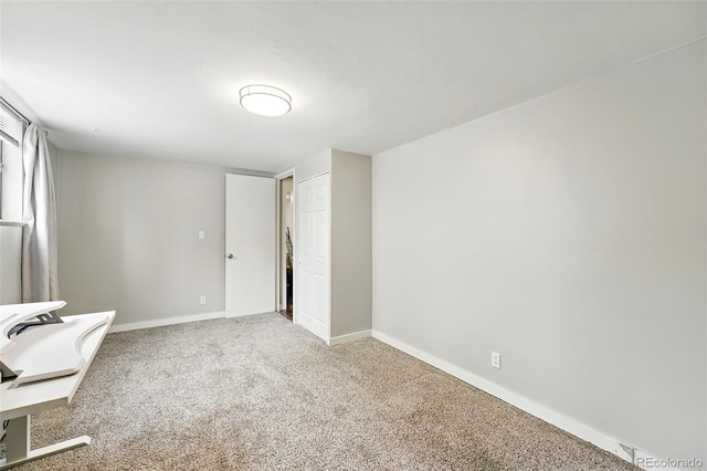 unfurnished room with light colored carpet and baseboards