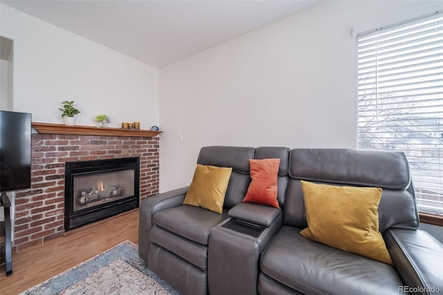 living room with light hardwood / wood-style flooring and a brick fireplace