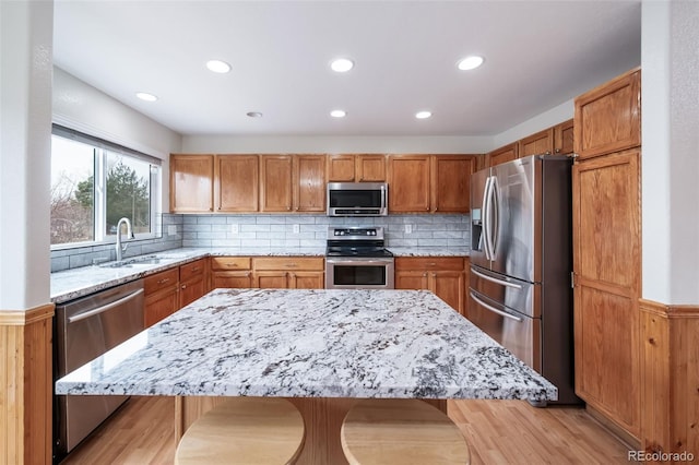 kitchen with a breakfast bar, a center island, sink, and appliances with stainless steel finishes