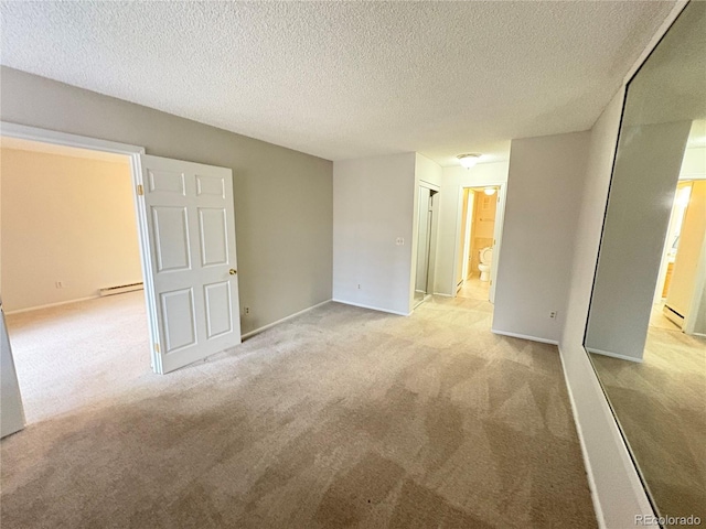 unfurnished bedroom featuring a baseboard heating unit, light carpet, a textured ceiling, and ensuite bathroom