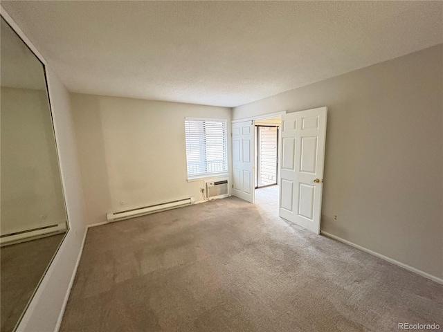 unfurnished bedroom featuring an AC wall unit, baseboard heating, carpet floors, and baseboards