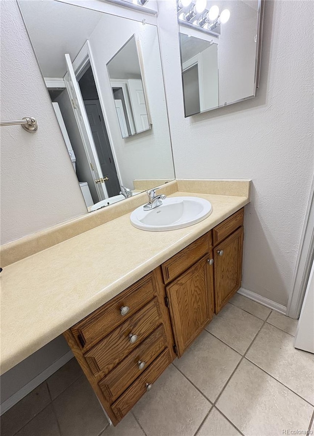 bathroom featuring tile patterned flooring, baseboards, and vanity