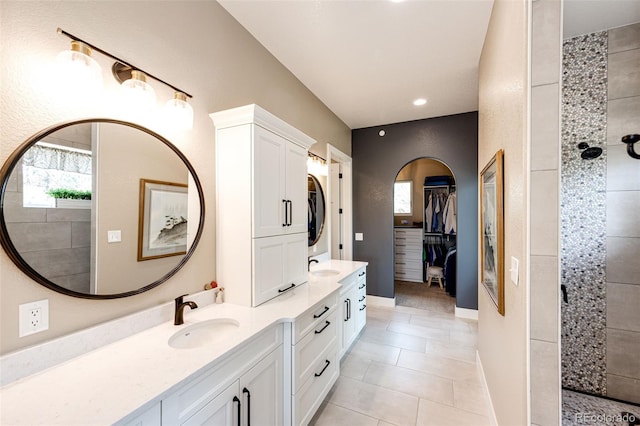 31455 Half Peak Trl, Pine, CO 80470 - bathroom featuring stacked washer and clothes dryer, double vanity, a tile shower, tile patterned floors, and recessed lighting