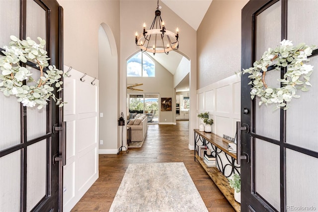 31455 Half Peak Trl, Pine, CO 80470 - foyer entrance with arched walkways, high vaulted ceiling, a chandelier, dark wood-type flooring, and baseboards