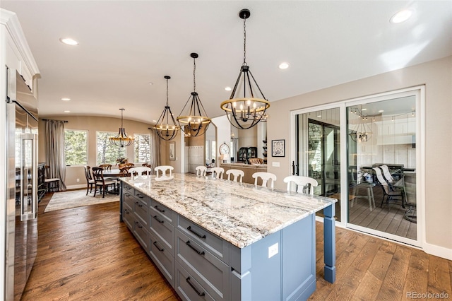 31455 Half Peak Trl, Pine, CO 80470 - kitchen with a breakfast bar area, gray cabinetry, a chandelier, vaulted ceiling, and dark wood finished floors