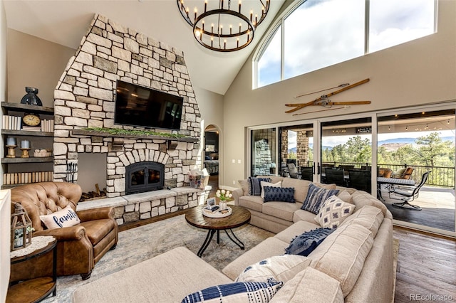31455 Half Peak Trl, Pine, CO 80470 - living area with a chandelier, wood finished floors, high vaulted ceiling, a stone fireplace, and arched walkways