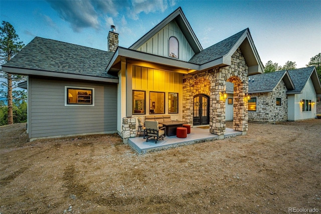 31455 Half Peak Trl, Pine, CO 80470 - rear view of house featuring board and batten siding, stone siding, a chimney, outdoor lounge area, and a patio