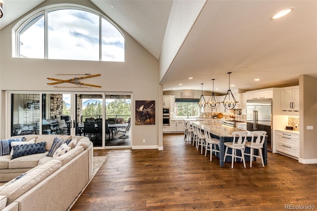 31455 Half Peak Trl, Pine, CO 80470 - living room with lofted ceiling, dark wood-type flooring, recessed lighting, baseboards, and a chandelier