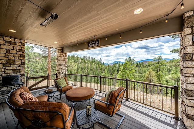 31455 Half Peak Trl, Pine, CO 80470 - wooden deck featuring an outdoor living space, a wooded view, and a mountain view