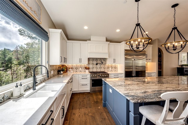 31455 Half Peak Trl, Pine, CO 80470 - kitchen featuring high end appliances, a sink, a chandelier, tasteful backsplash, and dark wood finished floors