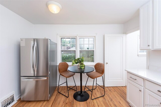 5680 W 41st Ave, Wheat Ridge, CO 80212 - kitchen featuring freestanding refrigerator, light wood-style floors, white cabinetry, and light countertops