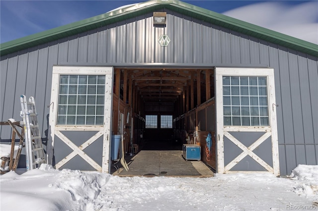 snow covered structure with an outbuilding