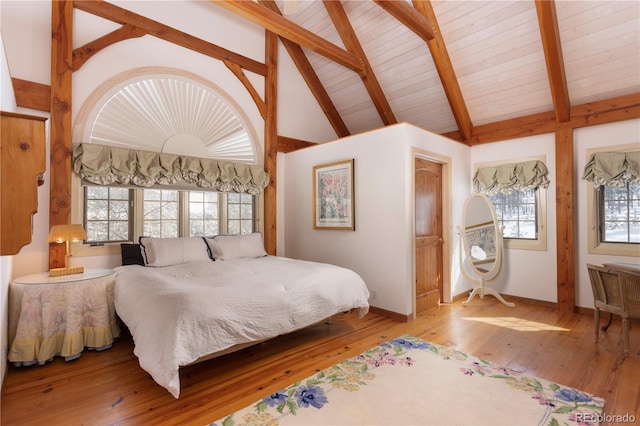 bedroom featuring baseboards, hardwood / wood-style flooring, wooden ceiling, high vaulted ceiling, and beam ceiling