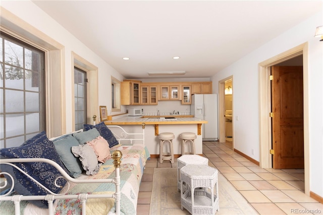 living room with light tile patterned floors, recessed lighting, and baseboards