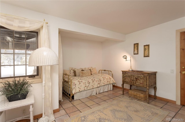 bedroom with baseboards and light tile patterned flooring