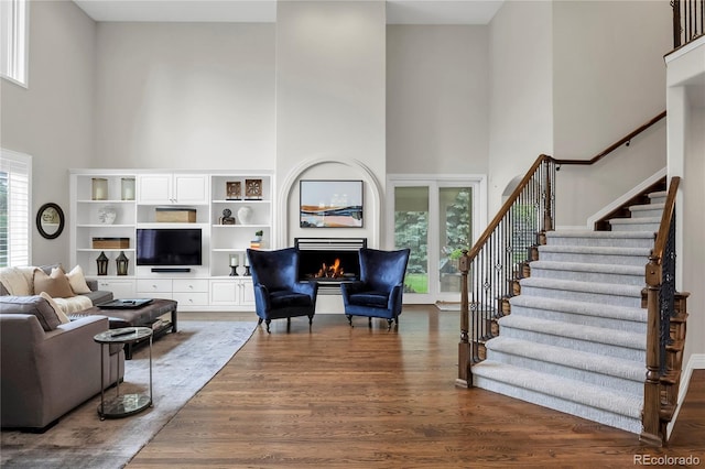 9669 E Prentice Cir, Greenwood Village, CO 80111 - living area featuring a high ceiling, stairs, dark wood-style floors, and a lit fireplace
