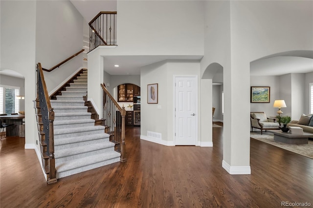 9669 E Prentice Cir, Greenwood Village, CO 80111 - entryway featuring a towering ceiling, arched walkways, stairs, and baseboards