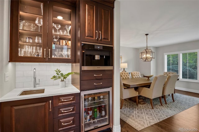 9669 E Prentice Cir, Greenwood Village, CO 80111 - bar area featuring wine cooler, a sink, backsplash, wood finished floors, and a chandelier