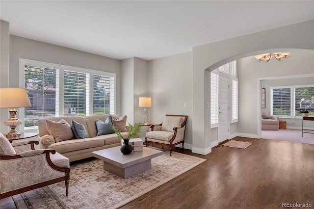 9669 E Prentice Cir, Greenwood Village, CO 80111 - living room with arched walkways, a chandelier, wood finished floors, and baseboards