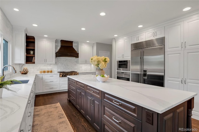 9669 E Prentice Cir, Greenwood Village, CO 80111 - kitchen with appliances with stainless steel finishes, a sink, custom exhaust hood, white cabinetry, and dark brown cabinets