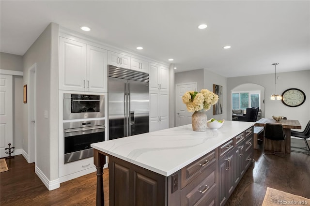 9669 E Prentice Cir, Greenwood Village, CO 80111 - kitchen featuring appliances with stainless steel finishes, white cabinets, dark wood-type flooring, a kitchen island, and recessed lighting