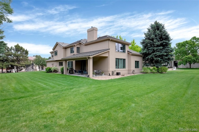 9669 E Prentice Cir, Greenwood Village, CO 80111 - back of house featuring a chimney, a lawn, a patio area, and stucco siding