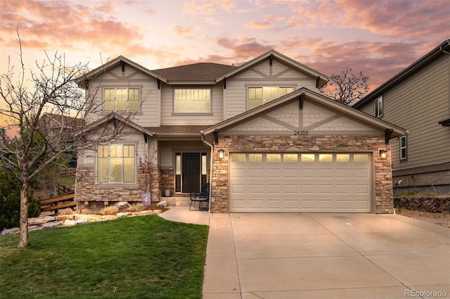 craftsman-style home featuring a garage, concrete driveway, a front lawn, and stone siding