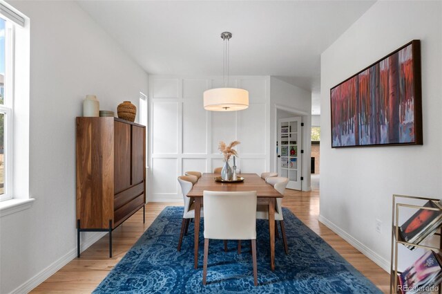 dining space featuring baseboards and light wood finished floors