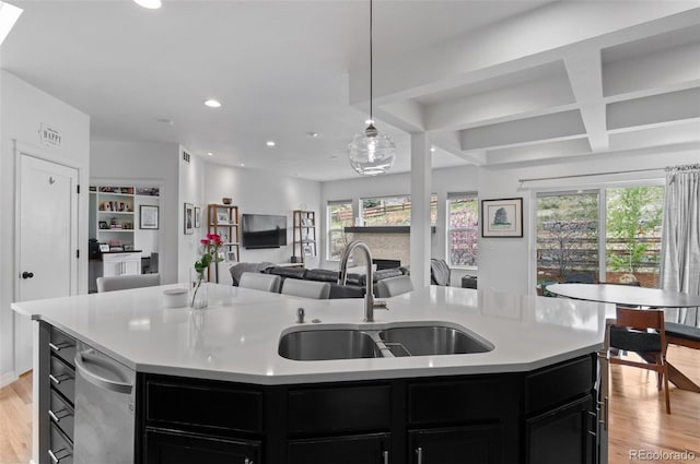 kitchen with a sink, dark cabinetry, plenty of natural light, and light wood-type flooring