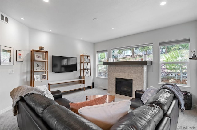 carpeted living room featuring recessed lighting, baseboards, visible vents, and a tile fireplace
