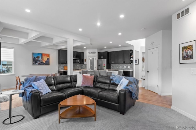 living room featuring light colored carpet, baseboards, visible vents, and recessed lighting
