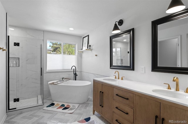 full bath featuring a sink, a marble finish shower, and a freestanding tub
