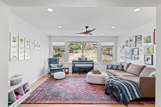 living room featuring a ceiling fan, recessed lighting, plenty of natural light, and wood finished floors